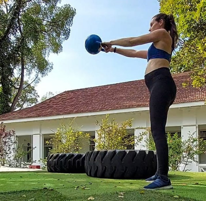 Pregnant women doing strength training with a kettlebell. 